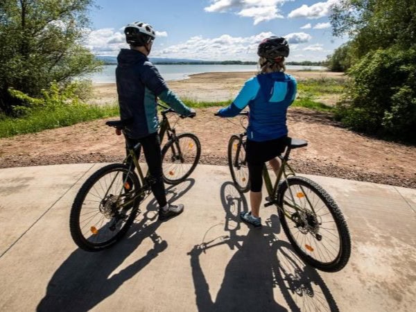 Dva cyklisté na cyklostezce u vodní nádrže Rozkoš